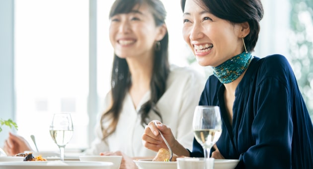 女性が笑顔で食事する様子